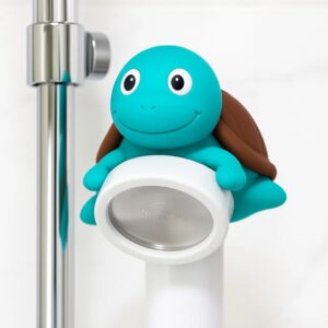 Colorful cartoon turtle robot with a friendly face, designed for entertainment and interaction, positioned next to a modern metal stand. Ideal for children's environments and playful spaces.